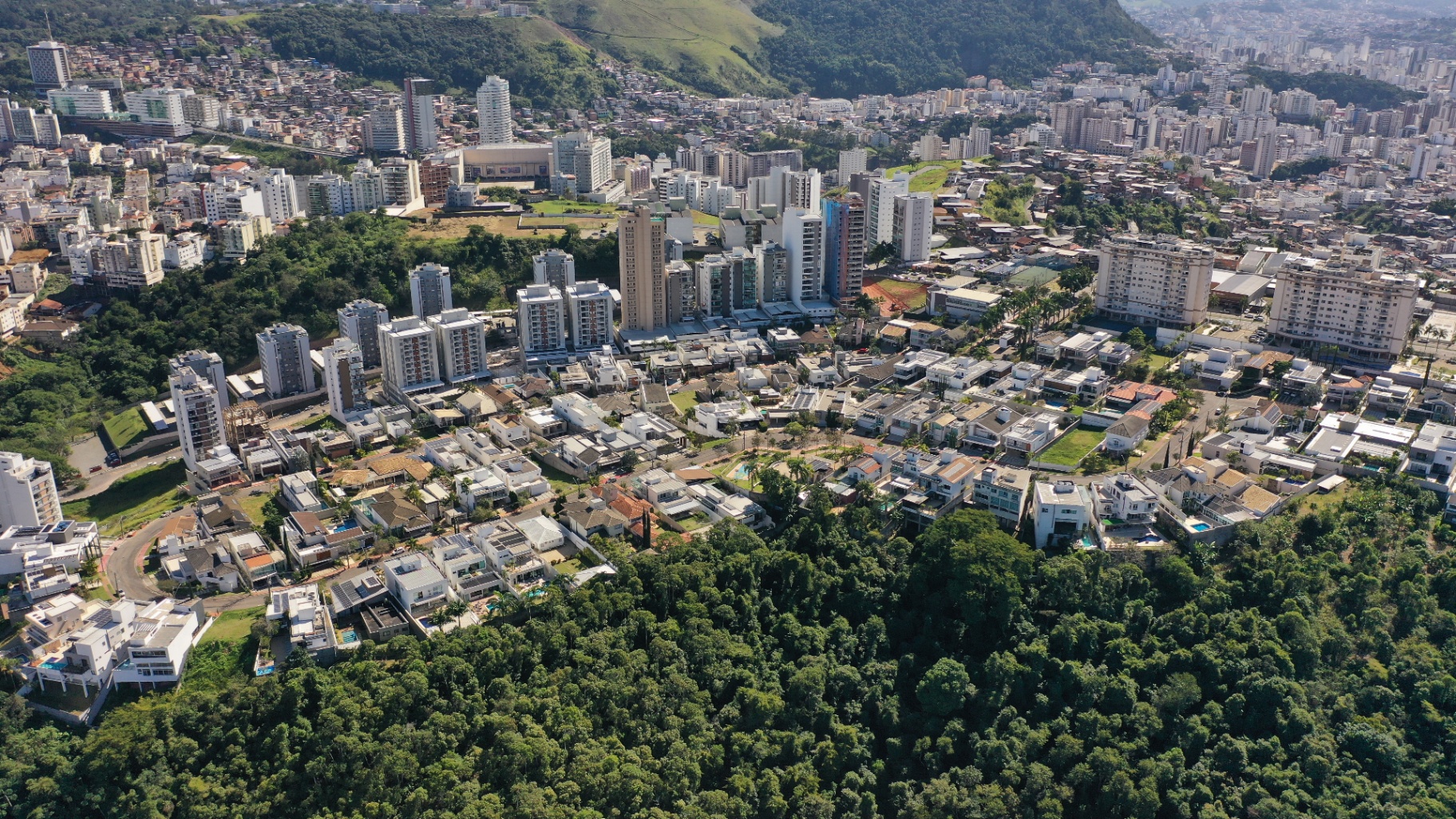 Vista aérea do Bairro Estrela Sul em Juiz de Fora, com a região residencial planejada cercada pela mata da Serra de São Geraldo