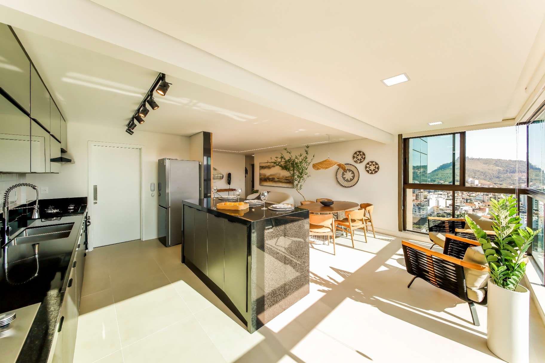 Cozinha com ilha em granito preto integrada ao living