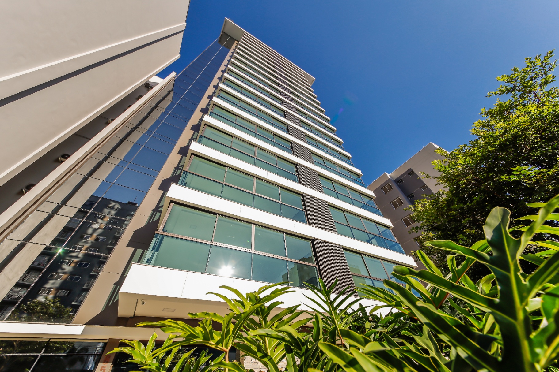 Fachada do MAP Estrela Sul em contra-plongée — torre única em vidro e concreto