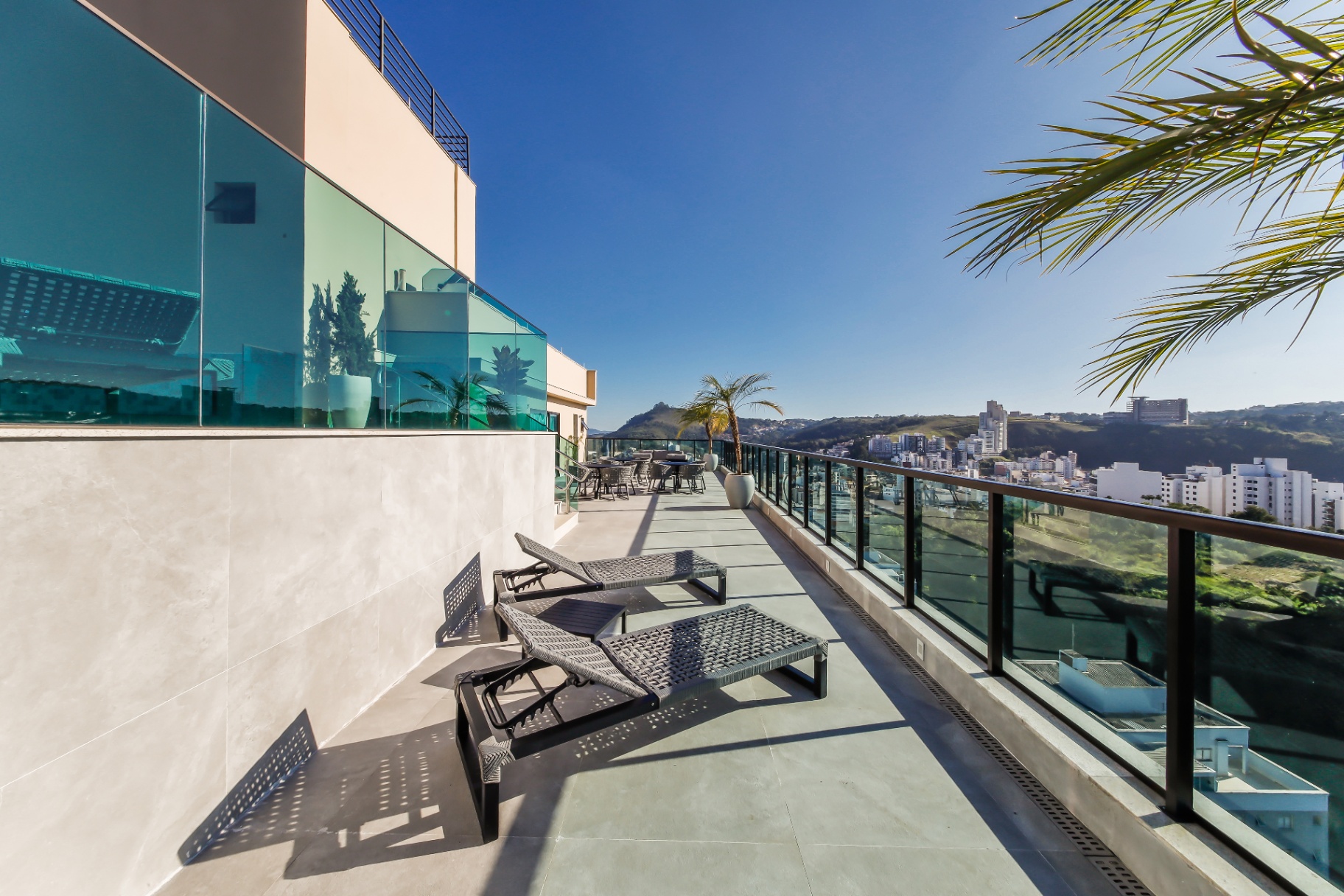 Solarium do rooftop com espreguiçadeiras voltadas para a Serra de São Geraldo